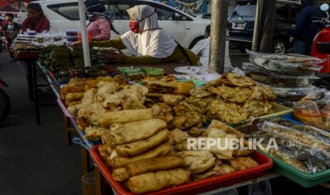 Pedagang melayani pembeli takjil di Jalan Panjang, Kebon Jeruk, Jakarta barat, Ahad (3/5). Belilah makanan secukupnya agar tidak ada yang terbuang.