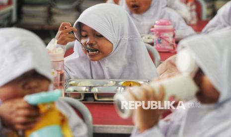 Para siswa menyantap hidangan Makan Bergizi Gratis (MBG). Program MBG tetap berjalan selama Ramadhan. Bagi siswa yang berpuasa, makanan bisa dibawa pulang.