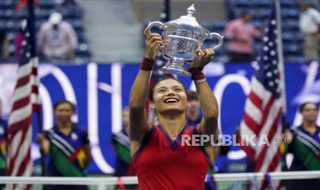  Emma Raducanu, dari Inggris, mengangkat trofi kejuaraan AS Terbuka setelah mengalahkan Leylah Fernandez, dari Kanada, pada final tunggal putri kejuaraan tenis AS Terbuka, Sabtu, 11 September 2021, di New York.