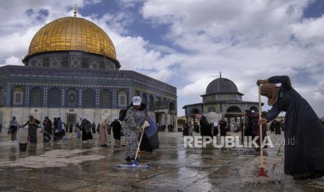 Relawan Palestina membersihkan tanah di luar Masjid Dome of Rock di kompleks Masjid Al-Aqsa menjelang bulan suci Ramadhan, di Kota Tua Yerusalem, Sabtu (18/3/2023).