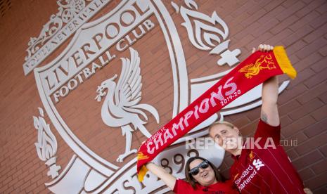  Fans Liverpool FC tersenyum ketika mereka berpose untuk foto saat merayakan di luar stadion Anfield di Liverpool, Inggris, 26 Juni 2020. Liverpool telah dinobatkan sebagai juara Liga Primer untuk pertama kalinya dalam tiga dekade setelah Chelsea FC mengalahkan Manchester City FC 2-1 pada Kamis malam, 25 Juni. Kegagalan Man City untuk memenangkan duel krusial ini secara matematis menyerahkan gelar liga ke klub Liverpudlian yang dipimpin oleh pelatih asal Jerman Juergen Klopp.