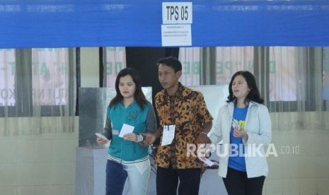 Dua orang disabilitas netra dibantu petugas saat melakukan pencoblosan di Pilkada Serentak Jawa Barat 2018 , di TPS 5, Aula Wyata Guna, Kota Bandung, Rabu (27/6).