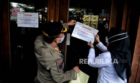 Petugas Satpol PP bersama Dinas Pariwisata dan Ekonomi Kreatif DKI, serta personel TNI melakukan penyegelan di salah satu bar-resto Holywings di Jakarta, Selasa (28/6/2022).rtifikat standar KBLI 56301 jenis usaha Bar yang telah terverifikasi. Republika/Thoudy Badai