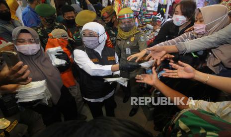 Gubernur Jawa Timur Khofifah Indar Parawansa (tengah) membagikan masker kepada pedagang dan pekerja di Pasar Kapasan, Surabaya, Jawa Timur, Senin (29/6/2020). Pembagian ribuan masker tersebut merupakan upaya mengedukasi masyarakat untuk bersama-sama mencegah penyebaran COVID-19 sekaligus menggelorakan gerakan 