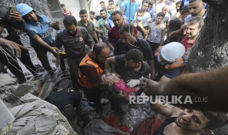 Warga Palestina menyelamatkan seorang anak dari bawah reruntuhan pasca serangan udara Israel di Kota Gaza, Jalur Gaza, Rabu, 17 Oktober 2023.