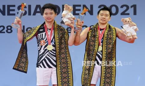 Ganda Putra Indonesia Marcus Fernaldi Gideon (kanan) dan Kevin Sanjaya Sukamuljo menunjukkan medali dan piala saat upacara penganugerahan juara Open 2021 usai mengalahkan Ganda Putra Jepang Takuro Hoki/Yugo Kobayashi di Nusa Dua, Bali, Ahad (28/11/2021). Marcus/Kevin berhasil menjuarai Indonesia Open 2021 setelah menang 21-14, 21-18 atas Ganda Putra Jepang. 