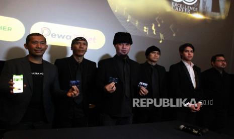 Tiga personel grup musik Dewa 19 Yuke Sampurna (kedua kiri), Ahmad Dhani (ketiga kiri) dan Andra Ramadhan (ketiga kanan) bersama tim promotor berpose usai konferensi pers Konser Orchestra di CGV FX Sudirman, Jakarta, Kamis (13/10/2022). Dewa 19 akan membawakan karya dengan aransemen orkestra untuk pertama kalinya dengan menggelar konser bertajuk “A Night At The Orchestra” di Balai Sarbini Hall, Jakarta, Jumat (25/11/2022). 