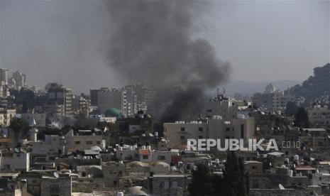 Asap mengepul saat bentrokan di tengah operasi Israel di kota tepi barat Nablus, 22 Februari 2023.