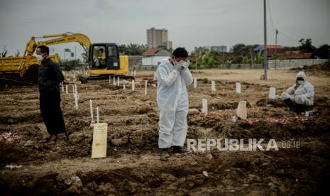 Keluarga memanjatkan doa saat prosesi pemakaman jenazah pasien Covid-19 di TPU khusus Covid-19 Rorotan, Jakarta Utara. Satuan Tugas Penanganan Covid-19 mencatat terjadinya penambahan kasus positif harian yang sebesar 22.053 kasus pada Kamis (19/8). Penambahan kasus positif pada hari ini menjadikan total kasus konfirmasi telah mencapai 3.930.300.