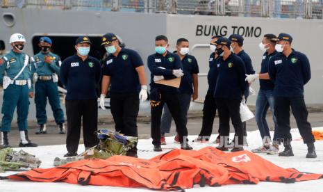  Anggota investigasi korban bencana berdiri di depan kantong mayat yang ditemukan dari lokasi kecelakaan di perairan Jakarta di pelabuhan Tanjung Priok di Jakarta. 