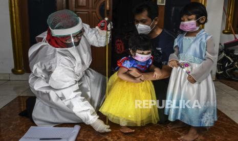 Kader Posyandu mengukur tinggi badan dari bocah saat melakukan pelayanan jemput bola di kawasan Green Garden, Rorotan, Jakarta Utara, Kamis (18/2/2021). Puskesmas Kelurahan Rorotan melakukan pelayanan jemput bola dikarenakan masih tingginya angka penularan COVID-19 di Ibu Kota. 