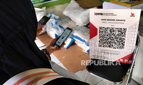 Pembeli memindai QR code untuk pembayaran beras operasi pasar di Kios Segoro Amarto, Pasar Beringharjo, Yogyakarta, Senin (13/2/2023). Sebanyak tiga ton beras premium disiapkan oleh Bank Indonesia guna operasi pasar untuk stabilitasi harga sembako sekaligus sarana sosialisasi pembayaran digital. Operasi pasar ini digelar karena ada kenaikan harga beras pada Januari dan Februari. Kegiatan ini dilakukan di tiga  tempat yakni Pasar Beringharjo, Pasar Kranggan, dan Pasar Prawirotaman yang bekerja sama dengan Kios Segoro Amarto.