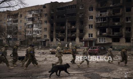 Tentara Ukraina berjalan di samping bangunan tempat tinggal yang rusak berat di Irpin, di pinggiran Kyiv, Ukraina, Rabu, 6 April 2022. Presiden Ukraina Volodymyr Zelenskyy mengatakan pasukan Rusia melakukan penyiksaan dan penculikan di selatan Ukraina.