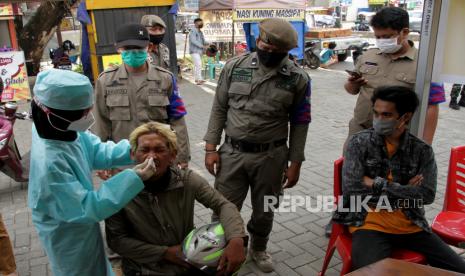 Petugas melakukan tes cepat antigen kepada warga yang melanggar protokol kesehatan (prokes) di Makassar, Sulawesi Selatan, Senin (9/8/2021). Sejumlah warga yang melanggar protokol kesehatan seperti tidak memakai masker di daerah itu langsung menjalani tes cepat antigen di tempat guna mengantisipasi penyebaran COVID-19.