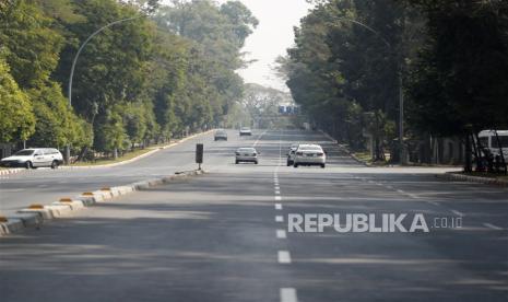  Mobil melaju di jalan kosong di Yangon, Myanmar, 1 Februari 2023. Militer Myanmar memperpanjang keadaan darurat .