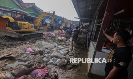 Petugas mengoperasikan alat berat untuk membersihkan material lumpur pascabanjir di Pasar Bojong Kulur, Vila Nusa Indah 2, Bojong Kulur, Gunung Putri, Kabupaten Bogor, Jawa Barat, Senin (10/3/2025).Pemerintah Kabupaten Bogor menargetkan penanganan banjir di Bojong Kulur, Gunung Putri selesai 10 hari pascakejadian. 