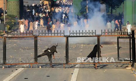 Pendukung mantan Perdana Menteri Pakistan Imran Khan melempar batu selama bentrokan dengan polisi saat mereka memprotes penangkapan Khan, di Peshawar, Pakistan, 09 Mei 2023. Khan, ketua Tehreek-e-Insaf Pakistan, ditahan oleh Akuntabilitas Nasional Bureau (NAB) pada 09 Mei di luar Pengadilan Tinggi Islamabad, di mana dia tiba untuk mengajukan jaminan dalam beberapa kasus yang diajukan terhadapnya. Penangkapan itu terjadi setelah penggulingan Khan dari kekuasaan pada April 2020 menyusul mosi tidak percaya yang gagal di parlemen.