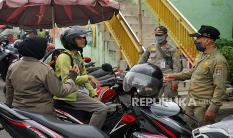 Petugas memberhentikan pengguna jalan yang tidak mengenakan masker saat razia masker di Pasar Karanggan Yogyakarta, Selasa (4/8/2020). Razia yang dilakukan oleh perugas gabungan dari Satpol PP, Polisi,  dan TNI Daerah Istimewa Yogyakarta itu guna mengedukasi masyarakat tentang pentingya penggunaan masker menyusul banyaknya khasus OTG COVID-19.