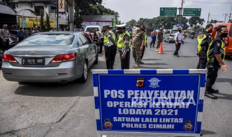 Petugas gabungan memeriksa identitas dan surat keterangan negatif Covid-19 dari pengemudi kendaraan dengan pelat nomor dari luar Bandung di gerbang Tol Padalarang, Kabupaten Bandung Barat, Senin (3/5). Penyekatan yang dilakukan oleh petugas gabungan dari Polisi, TNI, Dishub dan Satpol PP tersebut merupakan bagian dari pelaksanaan larangan mudik Hari Raya Idul Fitri 1442 H yang berlaku pada 6-17 Mei 2021. 