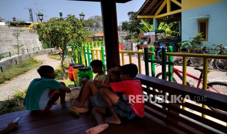 Anak-anak bermain di bungalow di jalur pedestrian pascarevitalisasi di tepi Sungai Gajahwong, Mujamuju, Yogyakarta. 