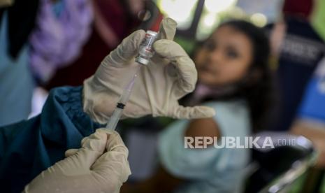 Tenaga kesehatan memasukan dosis vaksin Covid-19 untuk disuntikan kepada seorang anak di SDN Kawung Luwuk, Kota Bogor, Jawa Barat, Rabu (15/12). Pemerintah Kota Bogor memulai vaksinasi Covid-19 untuk anak usia 6-11 tahun dengan target sasaran berjumlah 100.862 jiwa. Republika/Putra M. Akbar