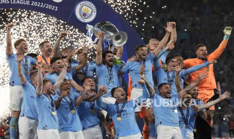 Kaptem Manchester City illkay Gundogan mengangkat trofi juara Liga Champions, Ahad (11/6/2023). 