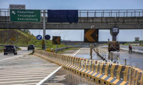 Pekerja menyiram ruas Jalan Tol Cileunyi-Sumedang-Dawuan (Cisumdawu) di Pamulihan, Kabupaten Sumedang, Jumat (22/4/2022). Arus mudik lintas Tol Cisumdawu di Kabupaten Sumedang, Jawa Barat pada H-6 Hari Raya Lebaran masih normal. 