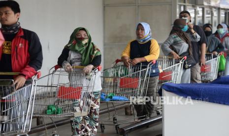 Warga mendorong troli untuk berbelanja. Membersihkan pegangan troli dengan tisu disinfektan lebih efektif untuk mengenyahkan virus penyebab Covid-19.