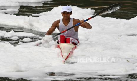 Pedayung nomor kayak DKI Jakarta Muhammad Fajar Maulana berlatih di antara busa-busa limbah di Sungai Banjir Kanal Timur, Marunda, Jakarta, Rabu (17/8/2022). Selain mencemari ekosistem setempat, banyaknya busa limbah rumah tangga dan sampah plastik di sungai tersebut mengakibatkan para atlet dayung DKI Jakarta yang memusatkan latihan mereka di lokasi tersebut menjadi terkendala dalam berlatih. 