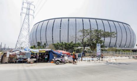 Pekerja melintasi tenda hunian darurat warga Kampung Bayam di depan pintu masuk Jakarta International Stadium (JIS), Jakarta, Rabu (20/9/2023). Sebanyak 11 Kepala Keluarga (KK) yang sudah bertahan selama 10 bulan di tenda hunian darurat akibat belum bisa menempati Kampung Susun Bayam tersebut rencananya akan direlokasi ke Rusun Nagrak oleh Pemerintah Provinsi DKI Jakarta untuk pembangunan trotoar jelang perhelatan Piala Dunia U-17.