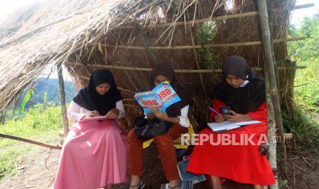 Sejumlah pelajar mengerjakan tugas di bawah pondok dengan menggunakan telepon gengam pintar di Jorong Sungai Guntung, Nagari Pasia Laweh, Kecamatan Palupuah, Kabupaten Agam, Sumatera Barat, Kamis (23/7/2020). Akses internet menjadi kendala utama pada pelaksanaan pembelajaran jarak jauh di era tatanan normal baru bagi pelajar yang tinggal di daerah pelosok di Kabupaten Agam, karena mereka harus berjalan kaki atau menggunakan sepeda motor sejauh delapan km dari rumah untuk mendapatkan jaringan internet. 