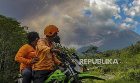 Warga menyaksikan Gunung Merapi mengeluarkan material vulkanik saat erupsi. 