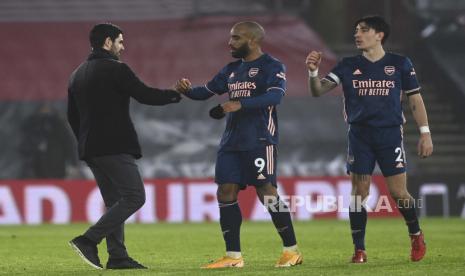 Manajer Arsenal Mikel Arteta, kiri, bersentuhan dengan Alexandre Lacazette dari Arsenal, tengah dan Hector Bellerin pada akhir pertandingan sepak bola Liga Utama Inggris antara Southampton dan Arsenal di stadion St Mary di Southampton, Inggris, Selasa 26 Januari 2021. 