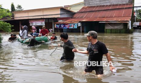 Warga melintasi banjir menggunakan perahu karet di Kelurahan Manggala, Makassar, Sulawesi Selatan, Rabu (12/2/2025). BPBD Kota Makassar mencatat sedikitnya 1.030 jiwa mengungsi akibat banjir yang merendam ratusan rumah warga di dua kecamatan dengan ketinggian air mencapai hingga dua meter di beberapa titik. 