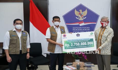 Kepala BNPB Doni Monardo (tengah) menerima bantuan senilai Rp2,75 miliar untuk Satuan Tugas (Satgas) Penanganan COVID-19 dari Presiden Komisaris PT Adaro Energy Tbk (Adaro) Edwin Soeryadjaya (kanan) disaksikan Ketua Relawan Satgas COVID-19 Andre Rahadian di Jakarta, Senin (29/3/2021). Bantuan yang diberikan melalui program “Adaro Berjuang untuk Indonesia” tersebut akan diperuntukkan bagi kegiatan operasional ambulan yang telah diserahkan perusahaan tahun lalu, yaitu berupa insentif SDM tenaga kesehatan, operasional dan APD tenaga medis. 