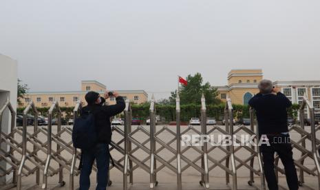 Sejumlah jurnalis asing memotret gedung perkantoran terpadu milik Pemerintah Kota Turban, Daerah Otonomi Xinjiang, China, Jumat (23/4/2021). Pemerintah China membantah klaim asing berdasarkan citra satelit yang menyebutkan  bahwa gedung tersebut merupakan penjara bagi warga dari kelompok etnis minoritas Muslim Uighur. 