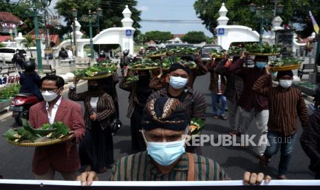 Warga yang tergabung dalam Forum Warga Yogyakarta menggelar aksi Bancakan Keistimewaan memperingati sembilan tahun disahkannya UU Keistimewaan Yogyakarta Nomor 13 Tahun 2012 di kawasan Titik Nol Km, Yogyakarta, Selasa (31/8/2021). Dalam aksi itu mereka menyerukan agar dana keistimewaan dialokasikan untuk bantuan sosial tunai bagi pelaku usaha kecil, PKL, dan pekerja informal yang terdampak pandemi. 