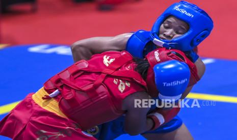 Atlet wushu putri Sumut Junita Malau (kanan) berusaha mengunci Atlet wushu putri Jatim Friska Ria Wibowo (kiri) saat bertanding pada semifinal Wushu Sanda Putri nomor 48 Kg PON Papua di Gor Futsal Dispora, Kabupaten Merauke, Papua, Jumat (1/10/2021). 