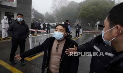 Personel keamanan menahan wartawan di pintu masuk ke Pusat Pengendalian dan Pencegahan Penyakit Hubei di mana tim Organisasi Kesehatan Dunia melakukan kunjungan lapangan di Wuhan di provinsi Hubei China tengah pada Senin (1/2/2021). Pejabat keamanan di salah satu provinsi terbesar di China, Henan, telah memasang sistem pengawasan untuk melacak jurnalis dan mahasiswa internasional.