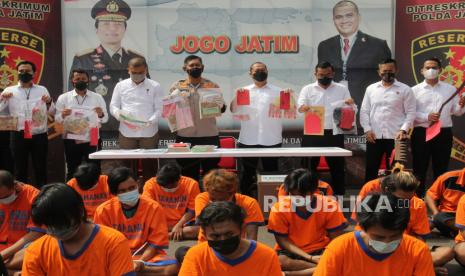 Polisi menunjukkan barang bukti dan tersangka saat ungkap kasus premanisme di Polda Jawa Timur, Surabaya, Jawa Timur, Senin (14/6/2021). Ditreskrimum Polda Jawa Timur bersama Polresta Sidoarjo, Polres Pelabuhan Tanjung Perak, Polres Mojokerto dan Polres Gresik menangkap 67 tersangka kasus dugaan premanisme dengan mengamankan sejumlah barang bukti beberapa diantaranya 69 bendel karcis pungutan liar, senjata tajam dan uang tunai Rp9.597.000. 