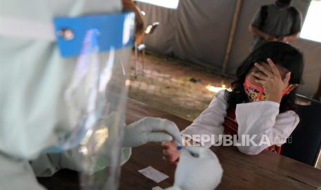 Seorang anak menuntup wajahnya saat tim medis mengambil sampel dalam rapid test gratis di posko gugus tugas COVID-19 di RS Bahteramas Kendari, Kendari, Sulawesi Tenggara, Selasa (2/6/2020). Pihak gugus tugas Sulawesi Tenggara menargetkan rapid test gratis kepada 1