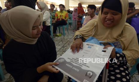 Petugas KPU Bandar Lampung mensosialisasikan contoh surat suara Braille untuk disabilitas di Bandar Lampung, Lampung, Ahad (11/2/2024). Komisi Pemilihan Umum Kota Bandar Lampung mengadakan sosialisasi pencoblosan yang menggunakan template huruf Braille yang akan digunakan sebagai alat bantu pencoblosan bagi penyandang tunanetra saat Pemilu 2024. 