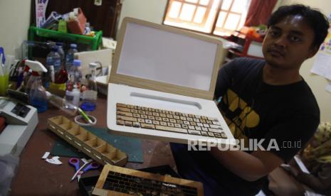 Perajin menunjukkan mainan edukasi laptop kayu di rumah produksi Pobeeid, Gentan, Sukoharjo, Jawa Tengah, Rabu (20/10/2020). Mainan edukasi tersebut dipasarkan secara daring untuk menjangkau pasar yang lebih luas dan banyak dipesan pembeli untuk merangsang kecerdasan kinestetik, logika, dan daya visual anak-anak. 