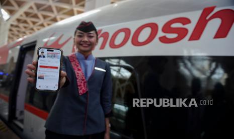 Petugas menunjukan aplikasi penjualan tiket WHOOSH pada aplikasi mobile saat menaiki kereta cepat WHOOSH di Stasiun Halim, Jakarta, Selasa (17/10/2023). 