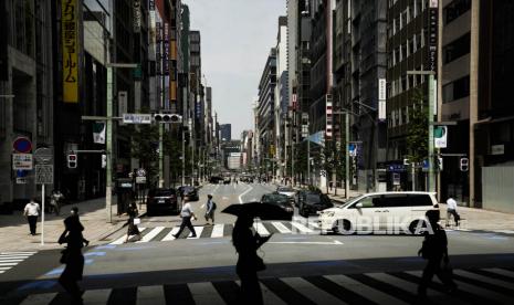 Orang-orang menyeberang jalan di distrik Ginza, Tokyo, Selasa (13/7). Keadaan darurat di empat prefektur diusulkan saat kasus Covid-19 di Jepang melonjak