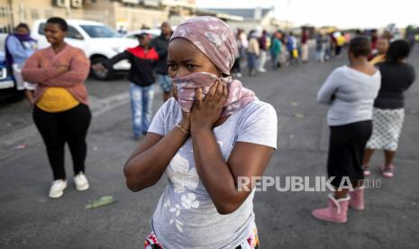 Warga menunggu antrean untuk hibah sosial dan membeli makanan dari pusat perbelanjaan selama hari kelima dari karantina nasional 21 hari di Khayelitsha, Cape Town, Afrika Selatan, Selasa (31/3). Petugas kesehatan dan polisi memiliki tugas yang sulit mendidik dan menegakkan jarak sosial di Khayelitsha