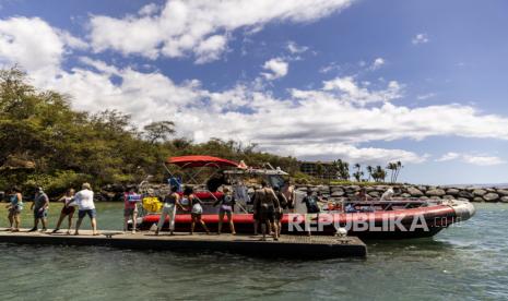   Relawan memuat perbekalan ke perahu menuju Maui Barat di dermaja Kihei, setelah kebakaran hutan menghancurkan sebagian besar kota bersejarah Lahaina, di pulau Maui, Hawaii, Ahad (13/8/2023).