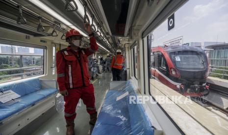 Sejumlah pekerja menaiki LRT saat pelaksanakan uji coba lintasan LRT Jabodebek. LRT Jabodebek kembali diuji coba untuk mengetes sistem persinyalan melalui lintas Stasiun TMII-Stasiun Harjamukti pada Rabu (11/11).