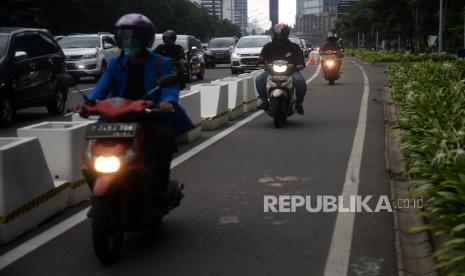 Pengedara sepeda motor melintas di jalur sepeda permanen di kawasan Sudirman, Jakarta, Jumat (5/3). Jalur sepeda permanen yang dibangun Pemprov DKI di kawasan Sudirman-Thamrin masih banyak ditemukan diserobot oleh pengendara motor. Wagub DKI Jakarta Ahmad Riza Patria menyatakan pihaknya akan meningkatan pengawasan terkait sejumlah kendaraan yang melintas di jalur sepeda permanen. Selain itu, dia mengaku akan mempersiapkan kemungkinan sanksi yang dapat diberikan kepada para pelanggar.Prayogi/Republika. 