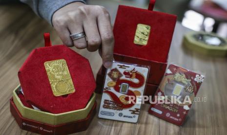 Petugas menunjukkan emas edisi Imlek berupa gambar Naga Kayu di Butik Emas Antam, Setia Budi, Jakarta, Jumat (2/2/2024). Emas Imlek Shio Naga hadir dengan berat 8 gram dan 88 gram, sementara untuk emas gift series Imlek hadir dengan berat 0,5 gram dan 1 gram. 